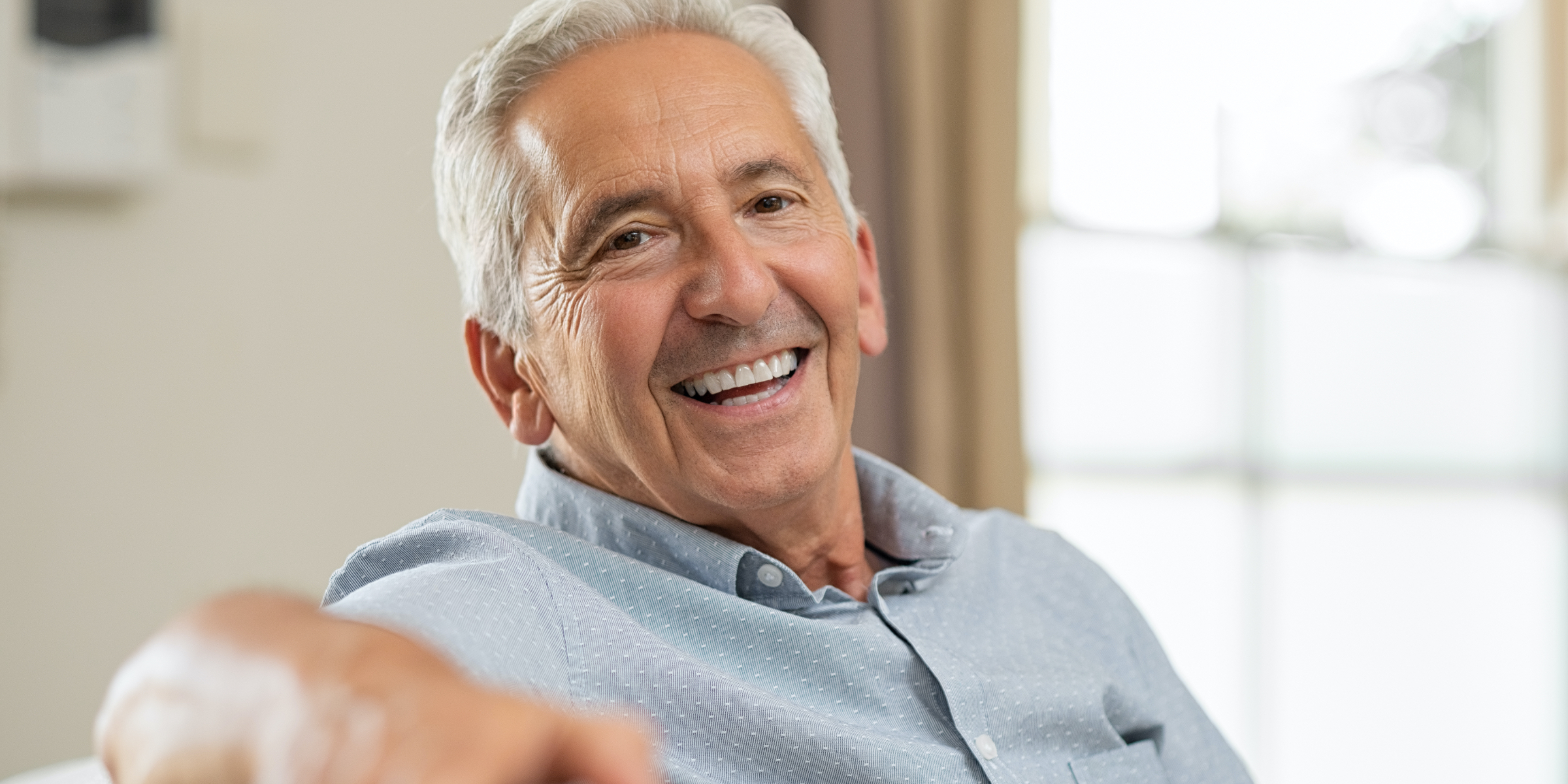 Smiling older man sitting on a couch