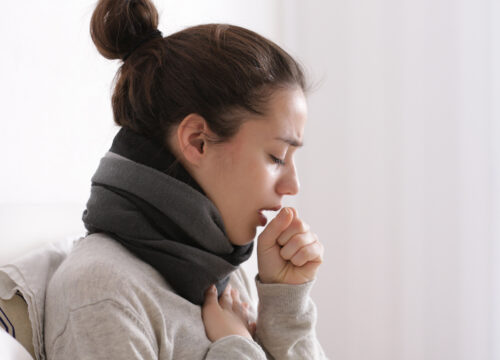 Photo of a woman with the flu coughing at home