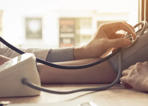 Photo of a doctor checking a patient's blood pressure
