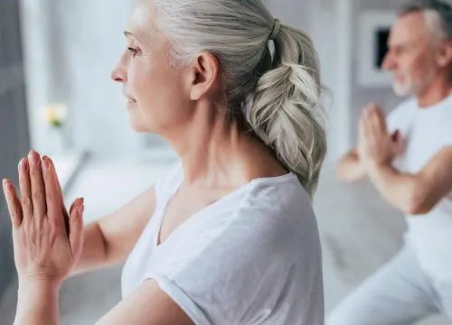 Woman doing yoga with her husband
