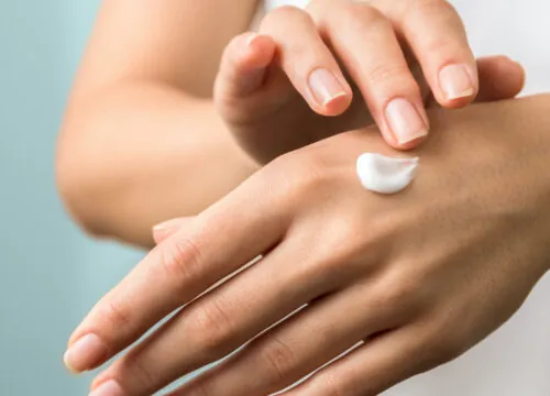 Photo of a woman applying skincare product to her hand