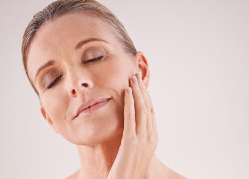 Photo of a middle age woman touching her face