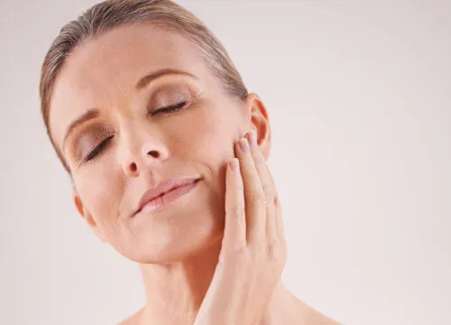 Photo of a middle age woman touching her face