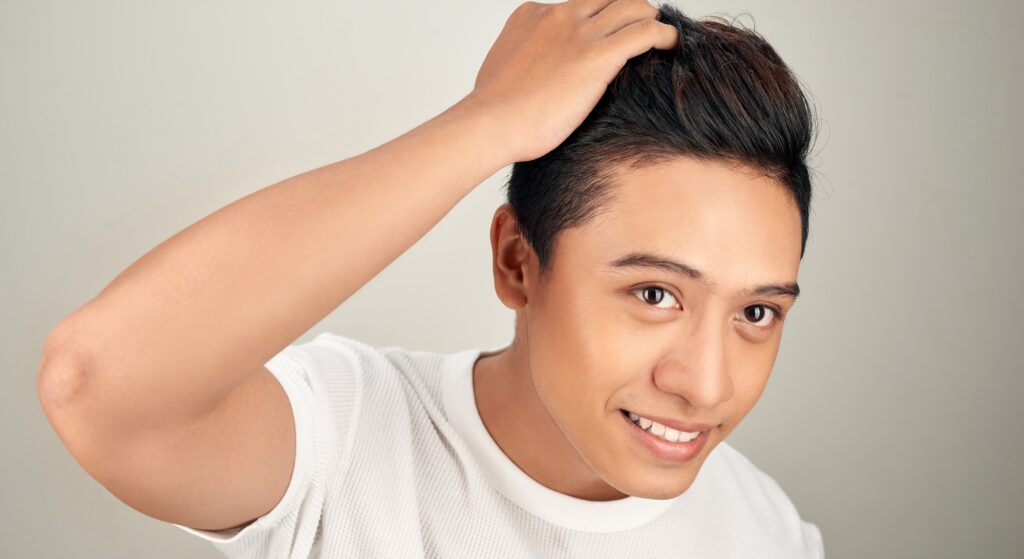 Photo of a man running his fingers through his hair
